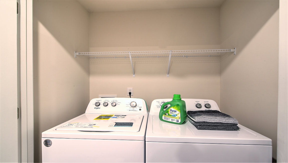 Laundry room with racks for storage or hanging above machines