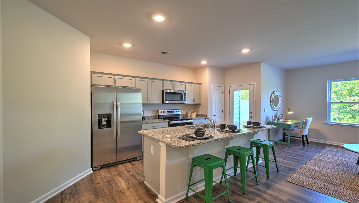 Kitchen and island with white cabinets, subway tile backsplash, and stainless steel appliances