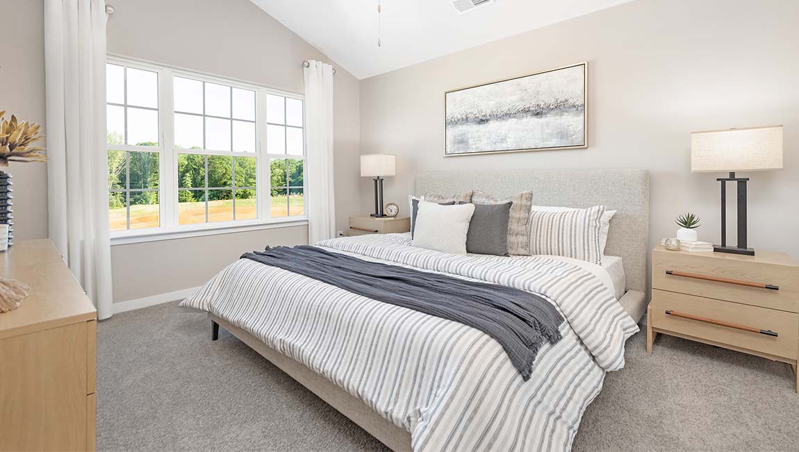 Carpeted primary bedroom with large window