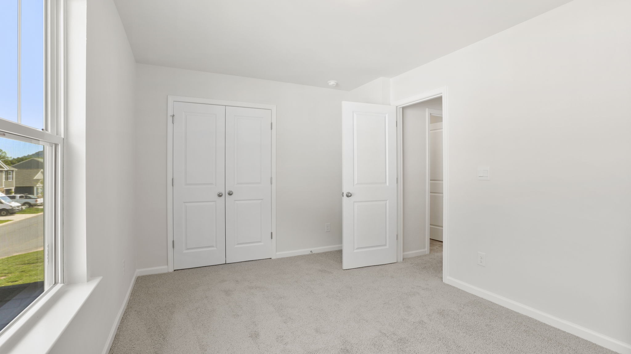 Carpeted bedroom with large windows