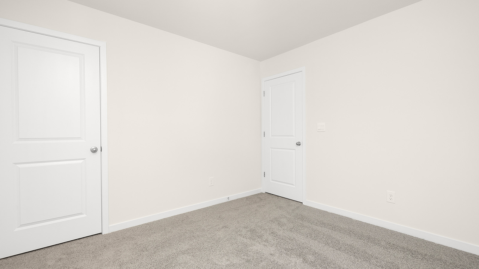 Carpeted bedroom with large window, view of bathroom door