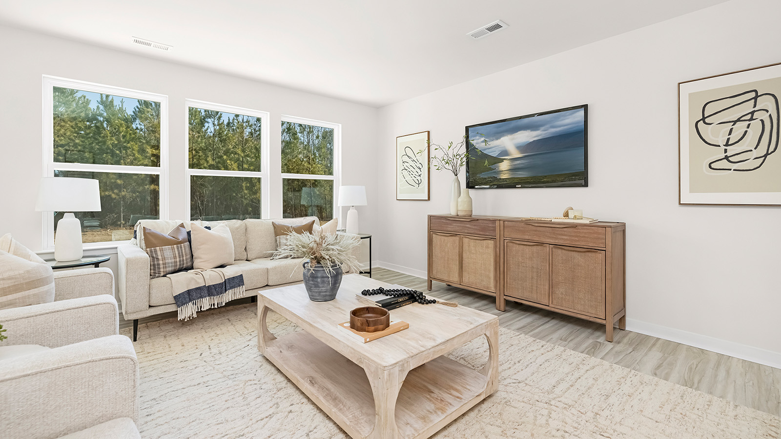 Living room space with wood floors, three large windows