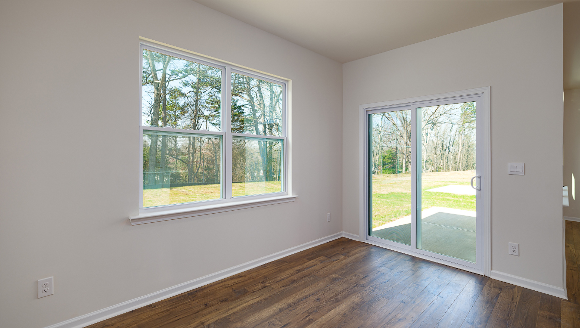 Breakfast area with wood floors, large window, and sliding glass back door