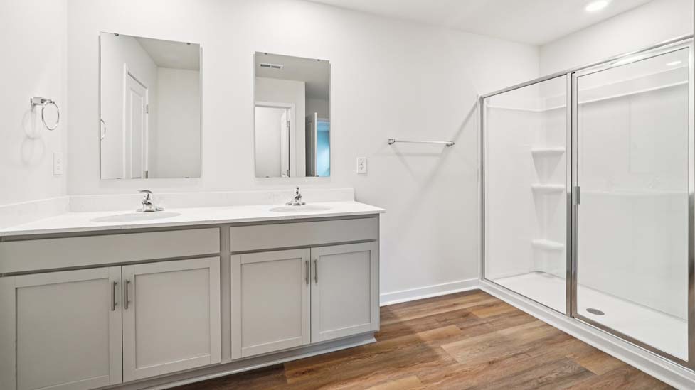 Primary bathroom with double vanity and walk in shower