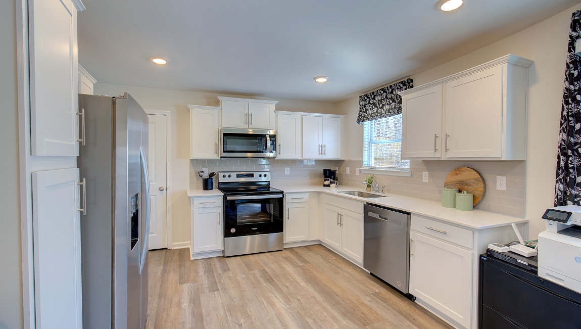 Kitchen with white cabinets, granite counters, subway tile backsplash and stainless steel appliances. New Homes in Asheville, North Carolina
