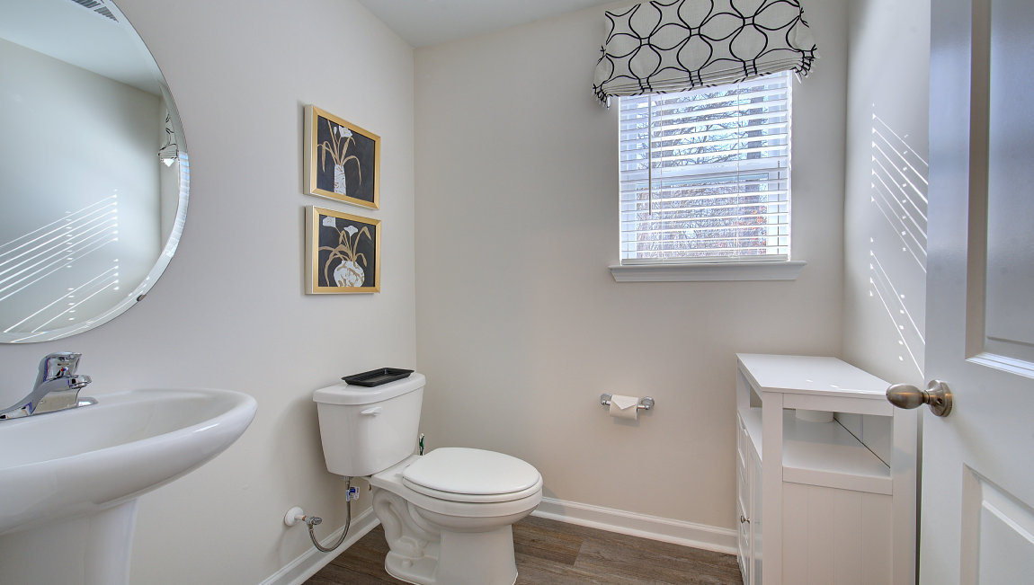 Powder bathroom with small sink, toilet, and window