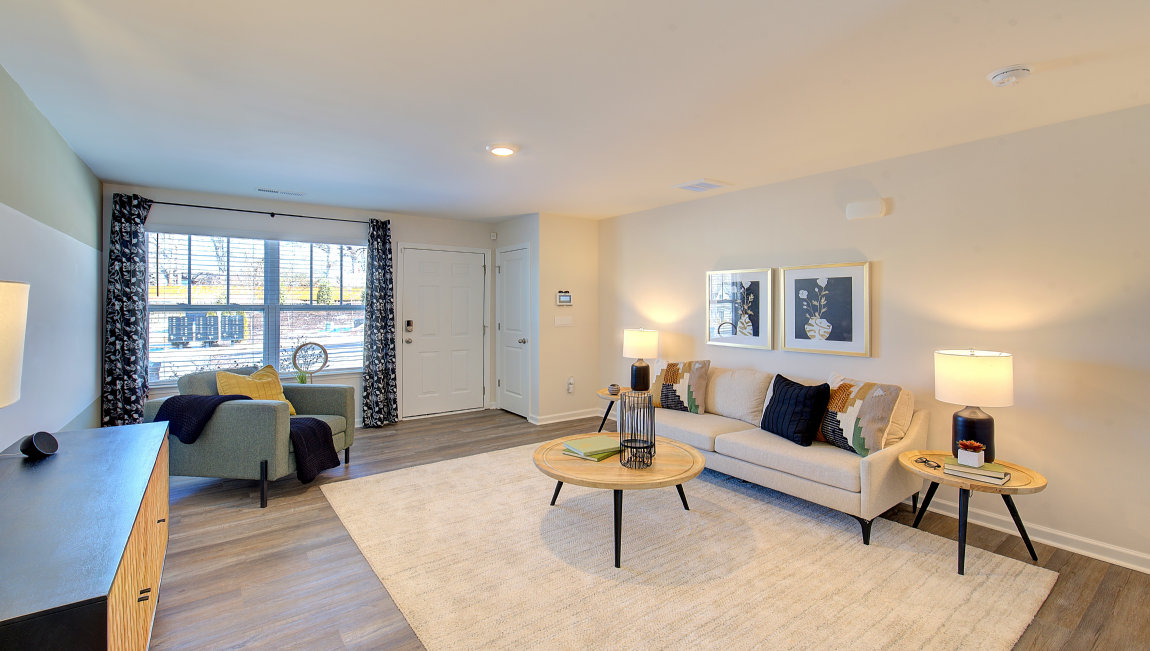 Living room by entryway with vinyl flooring and large window. New Homes in Asheville, North Carolina