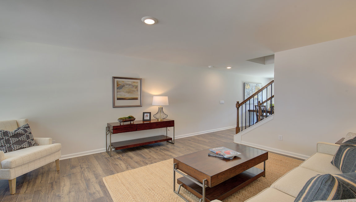 Living room by entryway with vinyl flooring and large window. New Homes in Asheville, North Carolina