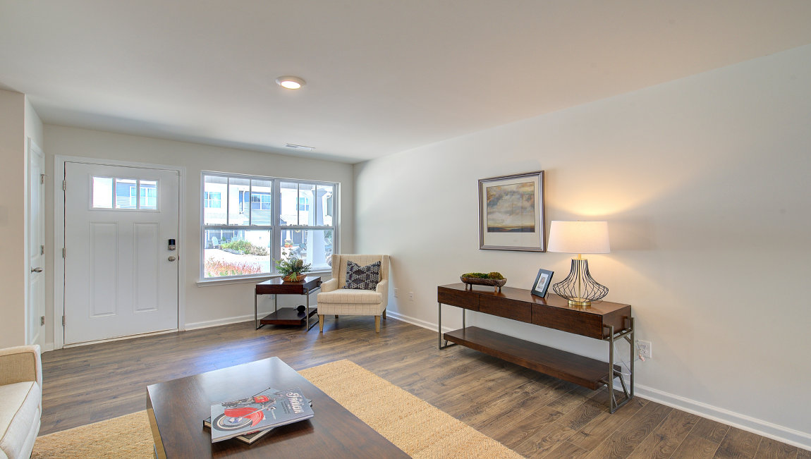 Living room by entryway with vinyl flooring and large window. New Homes in Asheville, North Carolina
