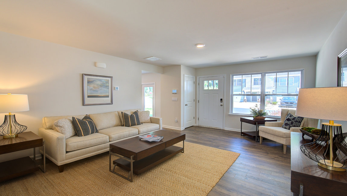 Living room by entryway with vinyl flooring and large window. New Homes in Asheville, North Carolina