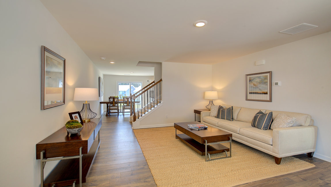 Living room by entryway with vinyl flooring and large window. New Homes in Asheville, North Carolina