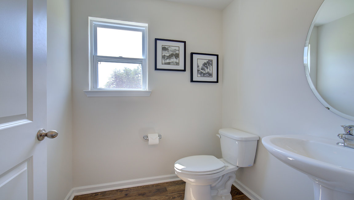 Powder bathroom with small sink, toilet, and window