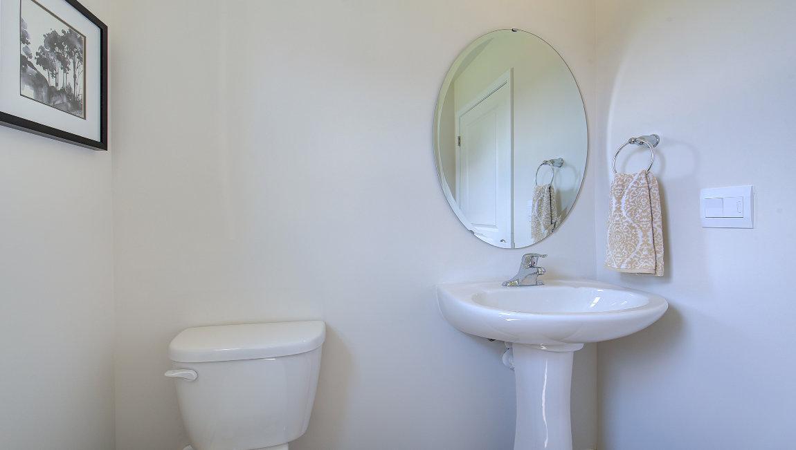 Powder bathroom with small sink, toilet, and window