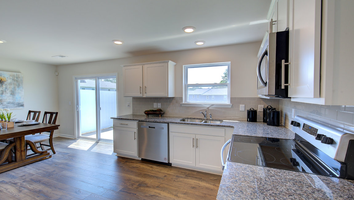 Kitchen with white cabinets, granite counters, subway tile backsplash and stainless steel appliances. New Homes in Asheville, North Carolina