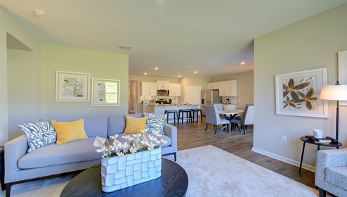 Living room with fireplace and large window with view of kitchen