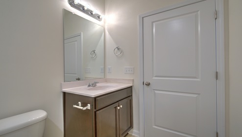 Primary bathroom with white counters and glass door shower