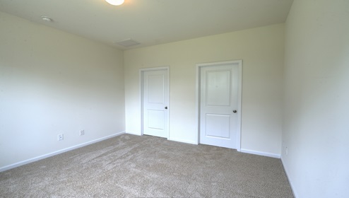 Primary carpeted bedroom with large window
