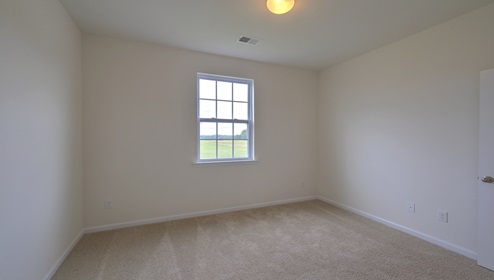 Carpeted bedroom with small window