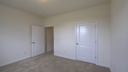 Carpeted bedroom view of entry door
