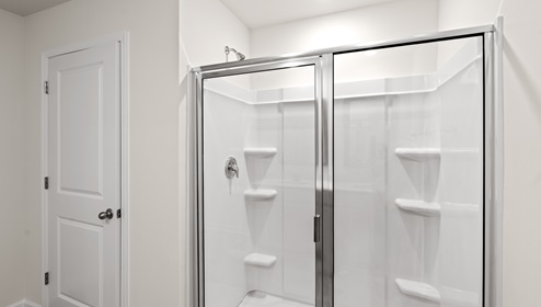 bathroom with double sinks and glass door shower