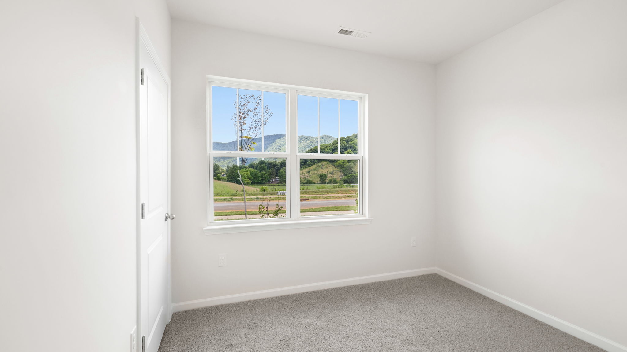Carpeted bedroom with large window