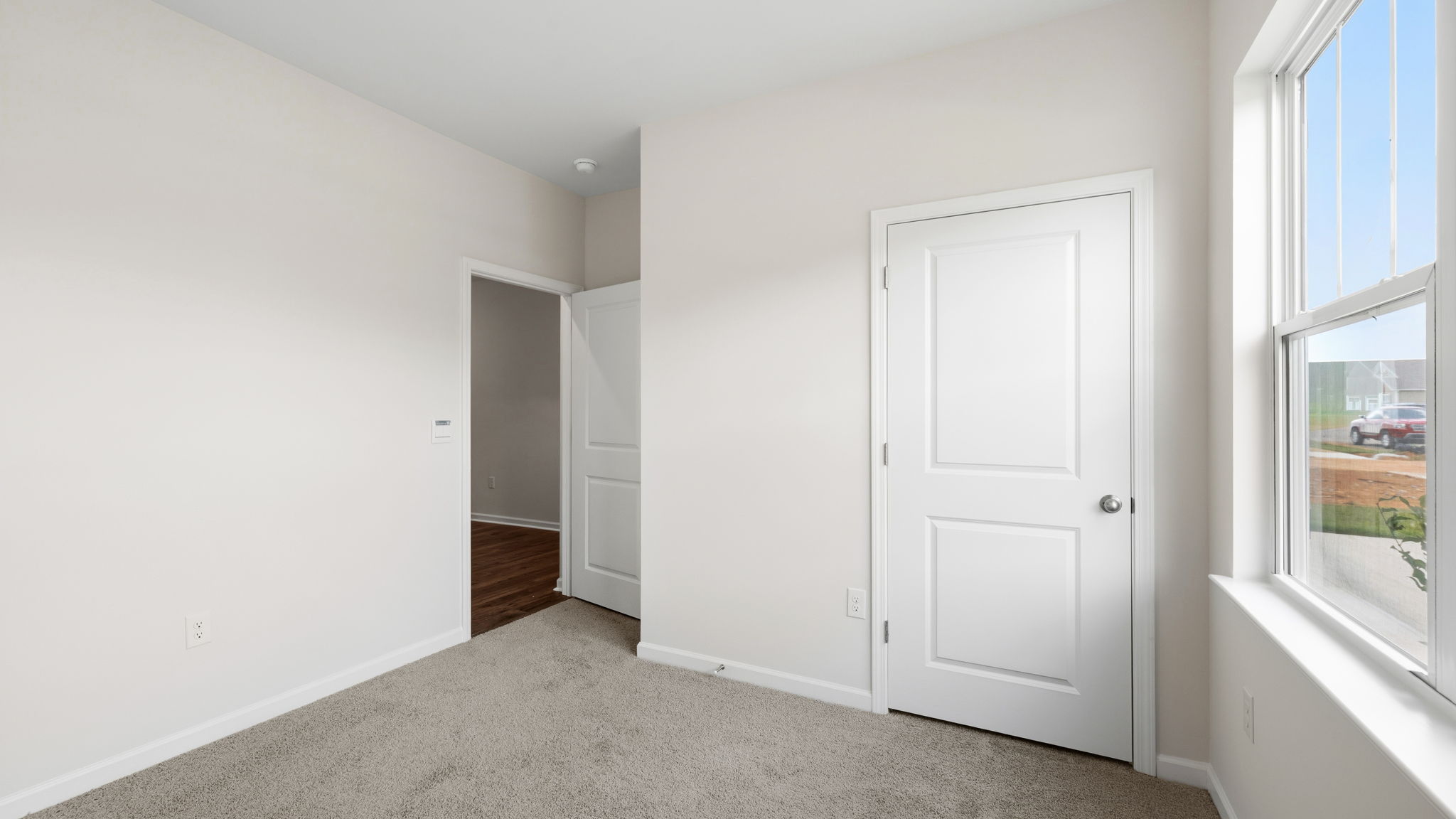 Carpeted bedroom with large window