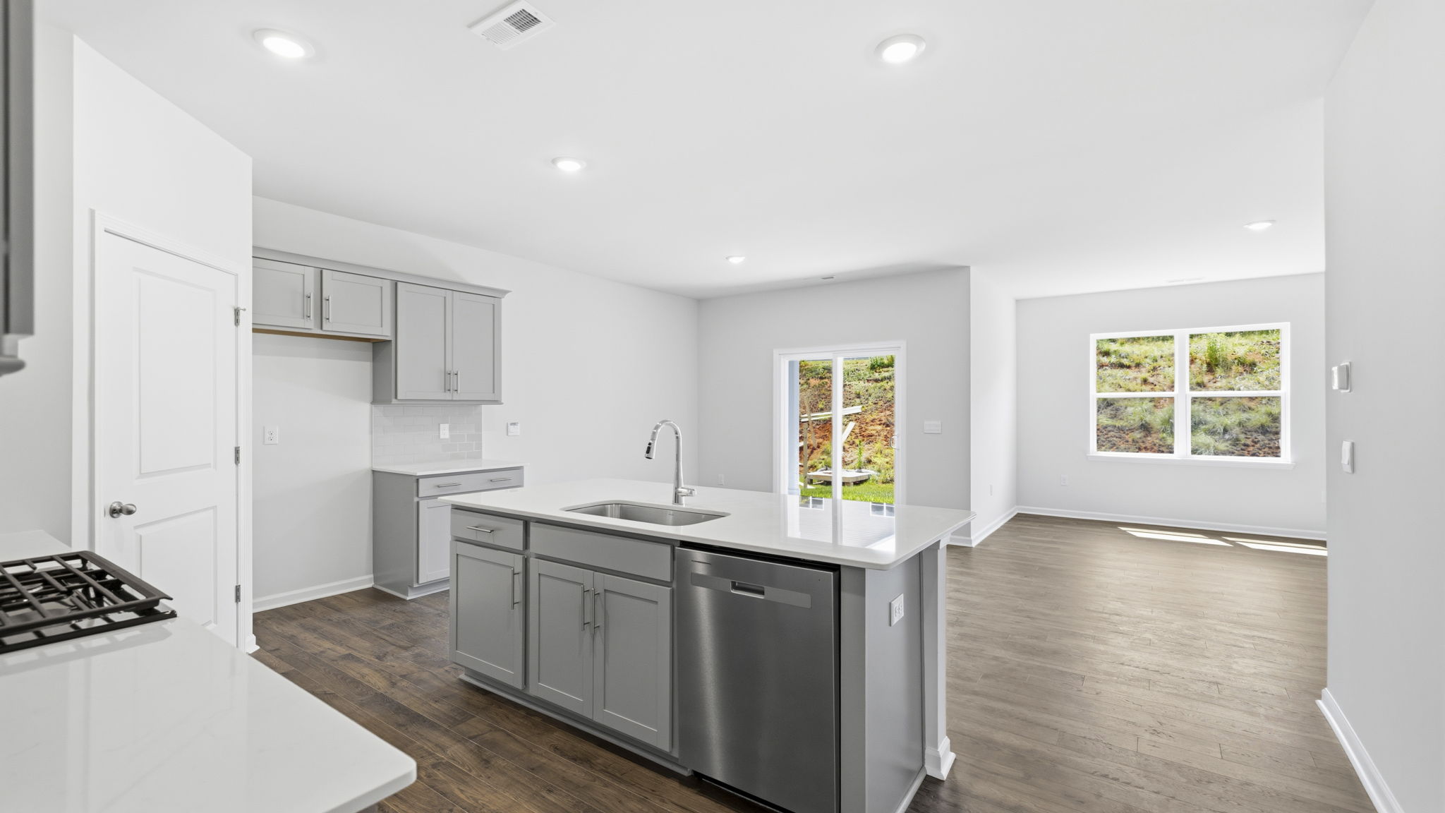 Open kitchen area with island and stainless steel appliances with view of living and dining areas