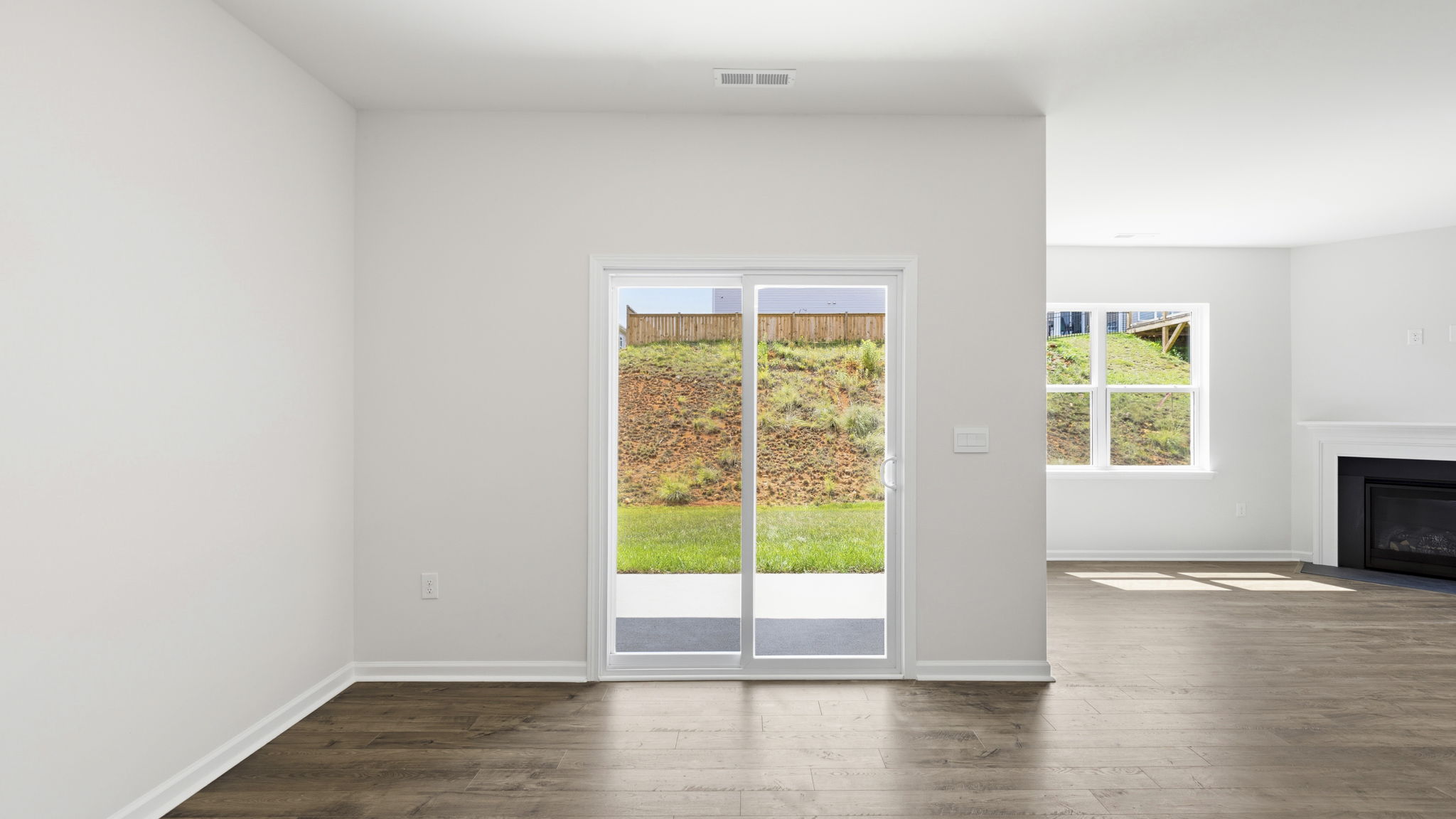 Dining area with sliding glass doors and view of living area with gas fireplace