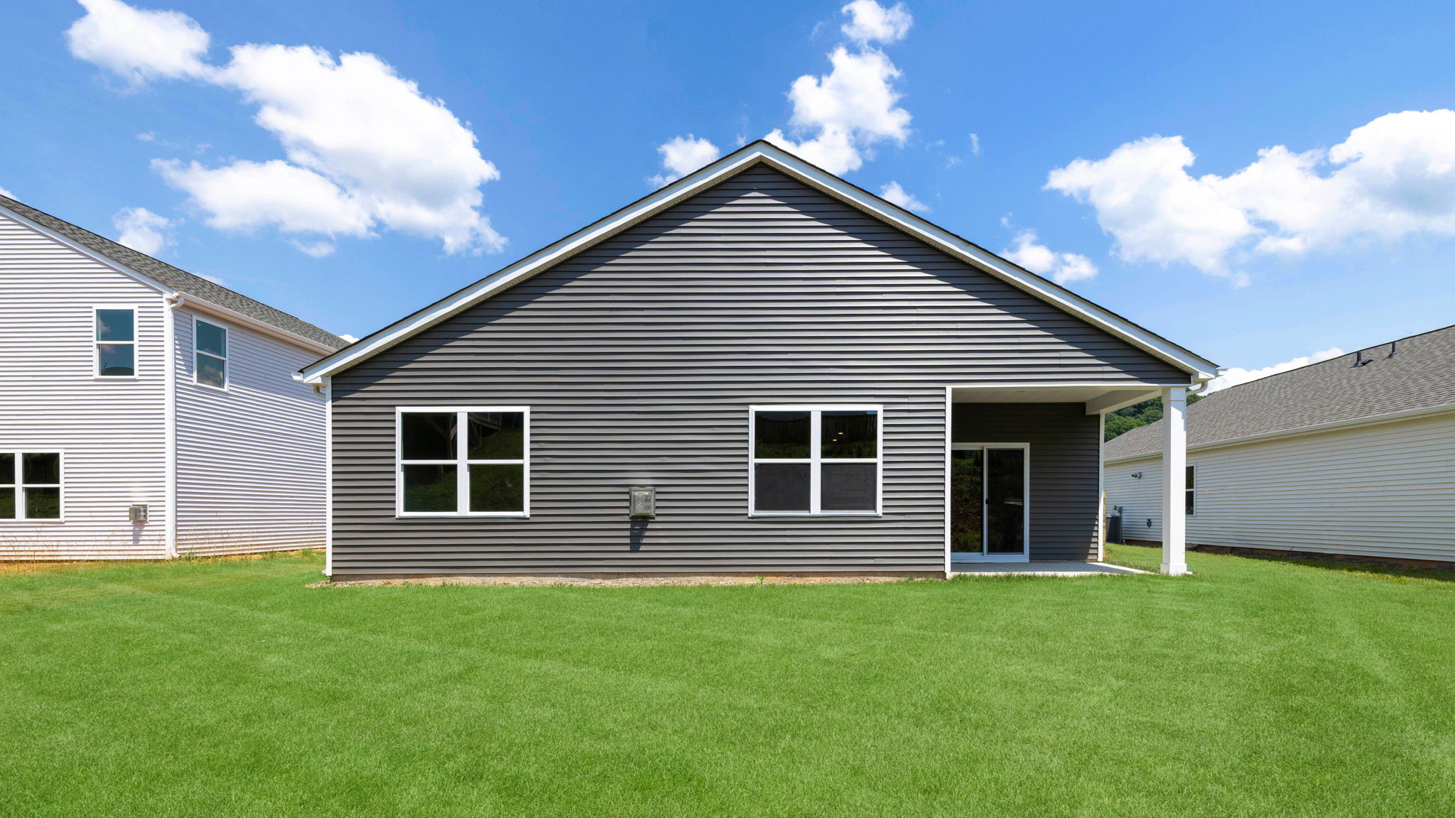 Exterior rear view of Cali floorplan with green grass and blue skies