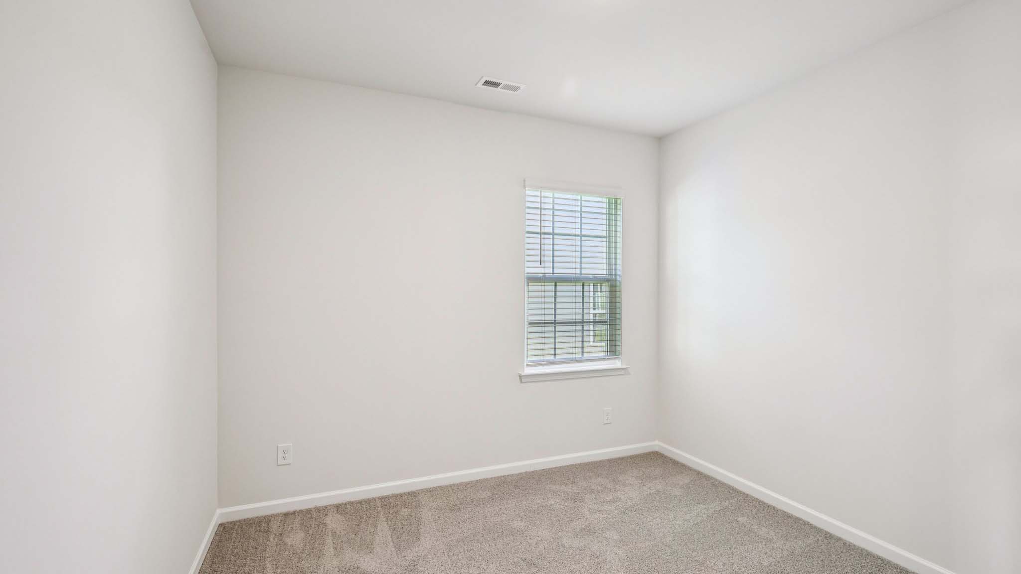 Carpeted bedroom with large windows