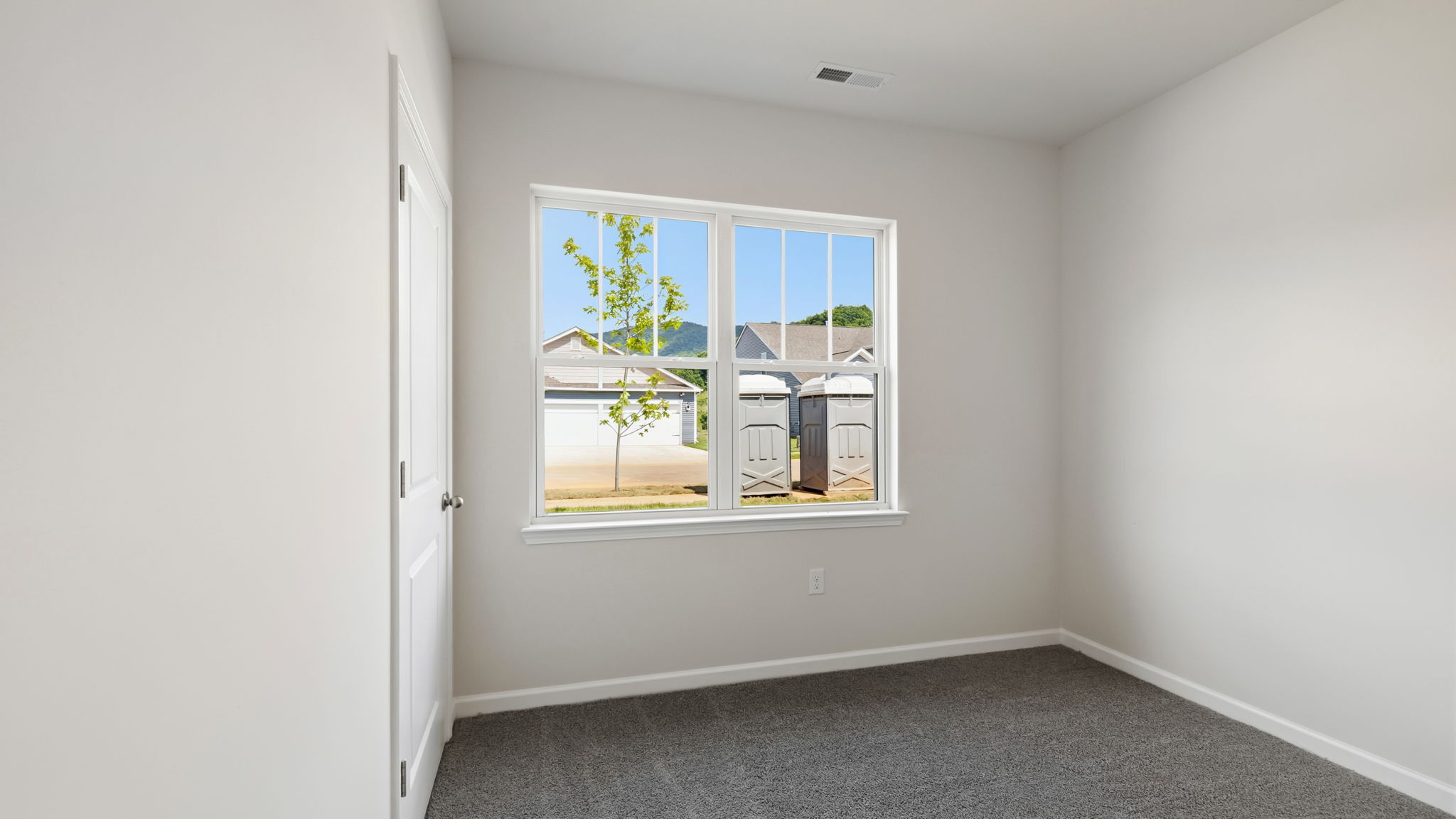 Carpeted bedroom with large window