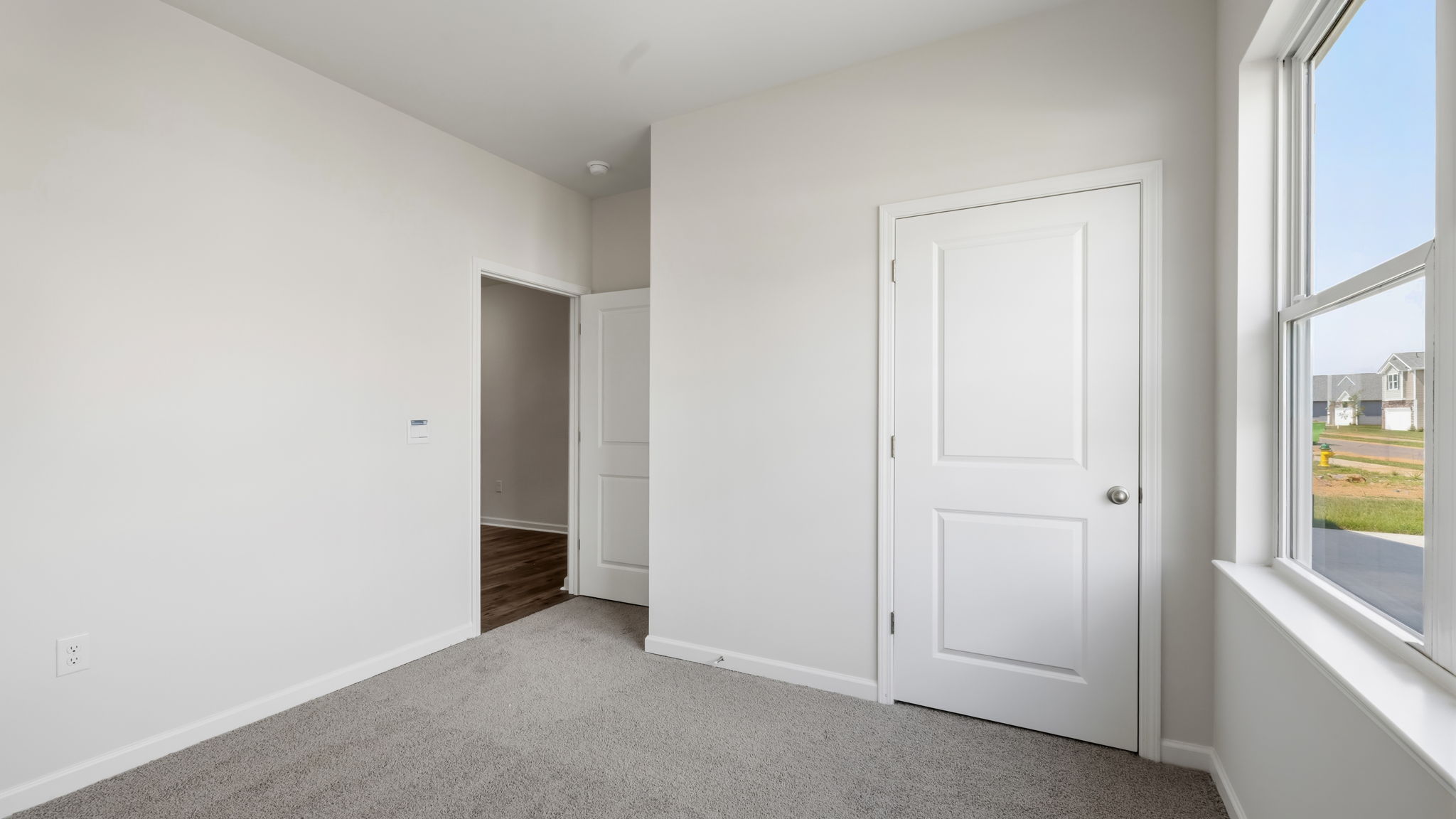 Carpeted bedroom with large window
