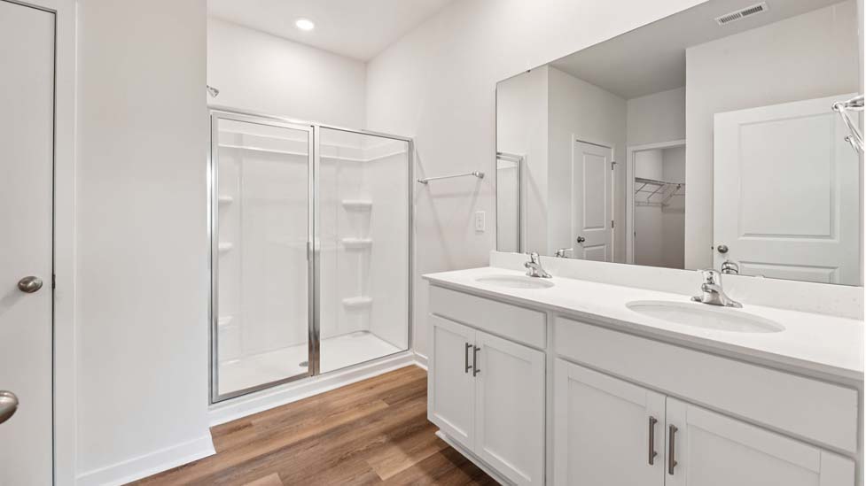 Primary bathroom with double vanity and walk in shower