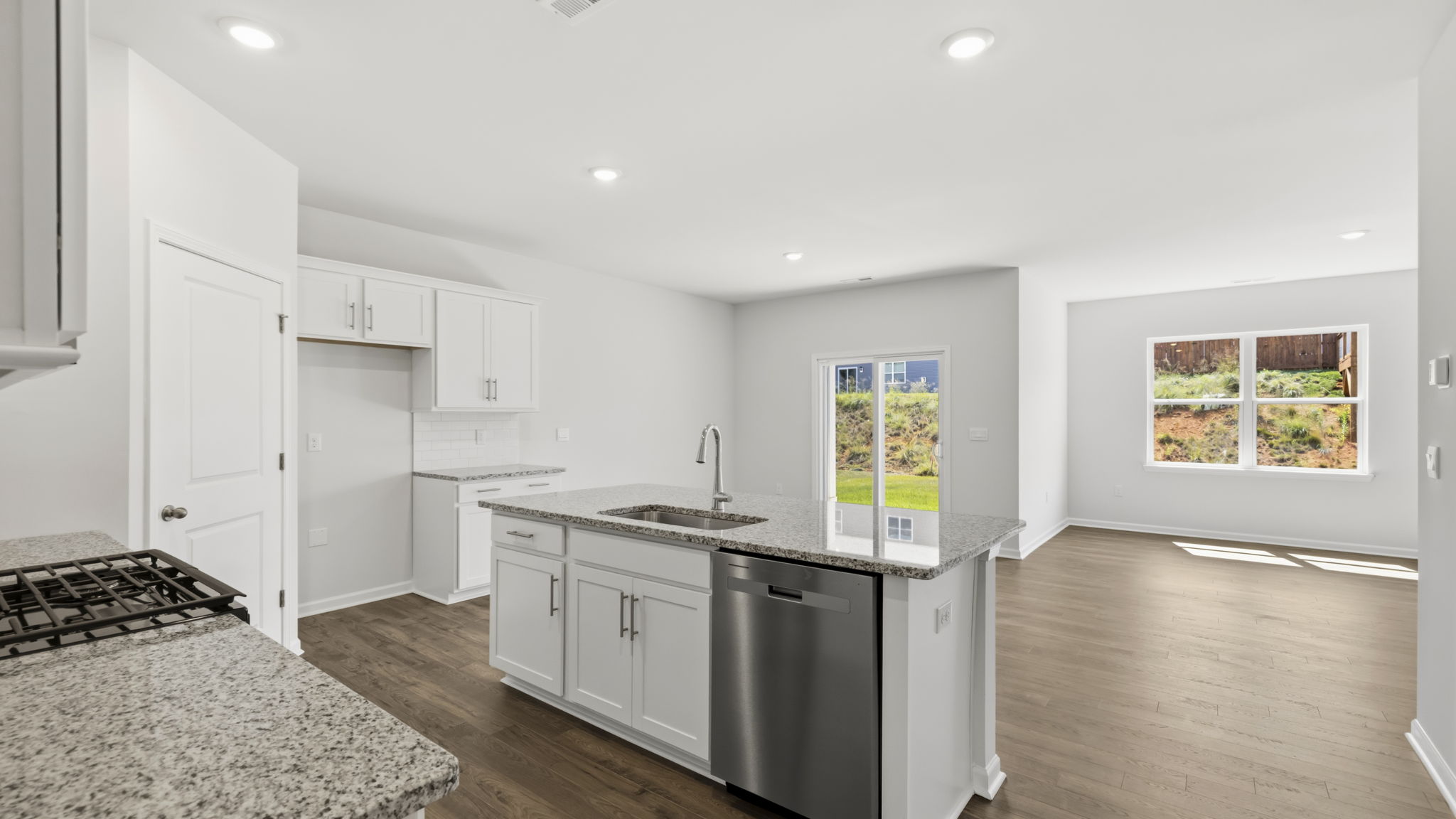 Open concept kitchen with large kitchen island, sliding glass doors and large windows