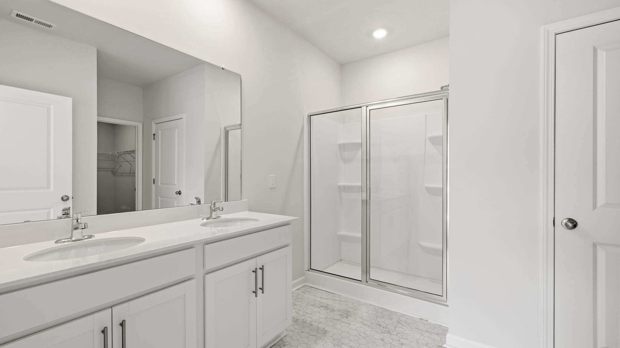 Primary bathroom with dual vanity and walk in shower