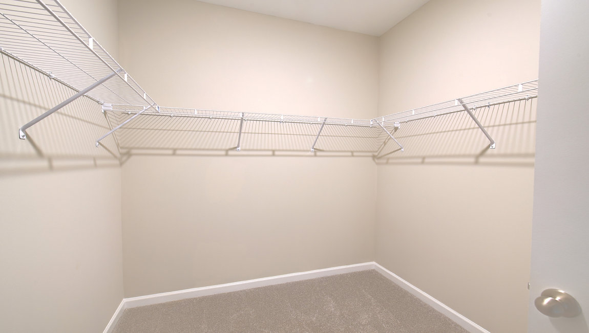 Primary walk in closet with shelving