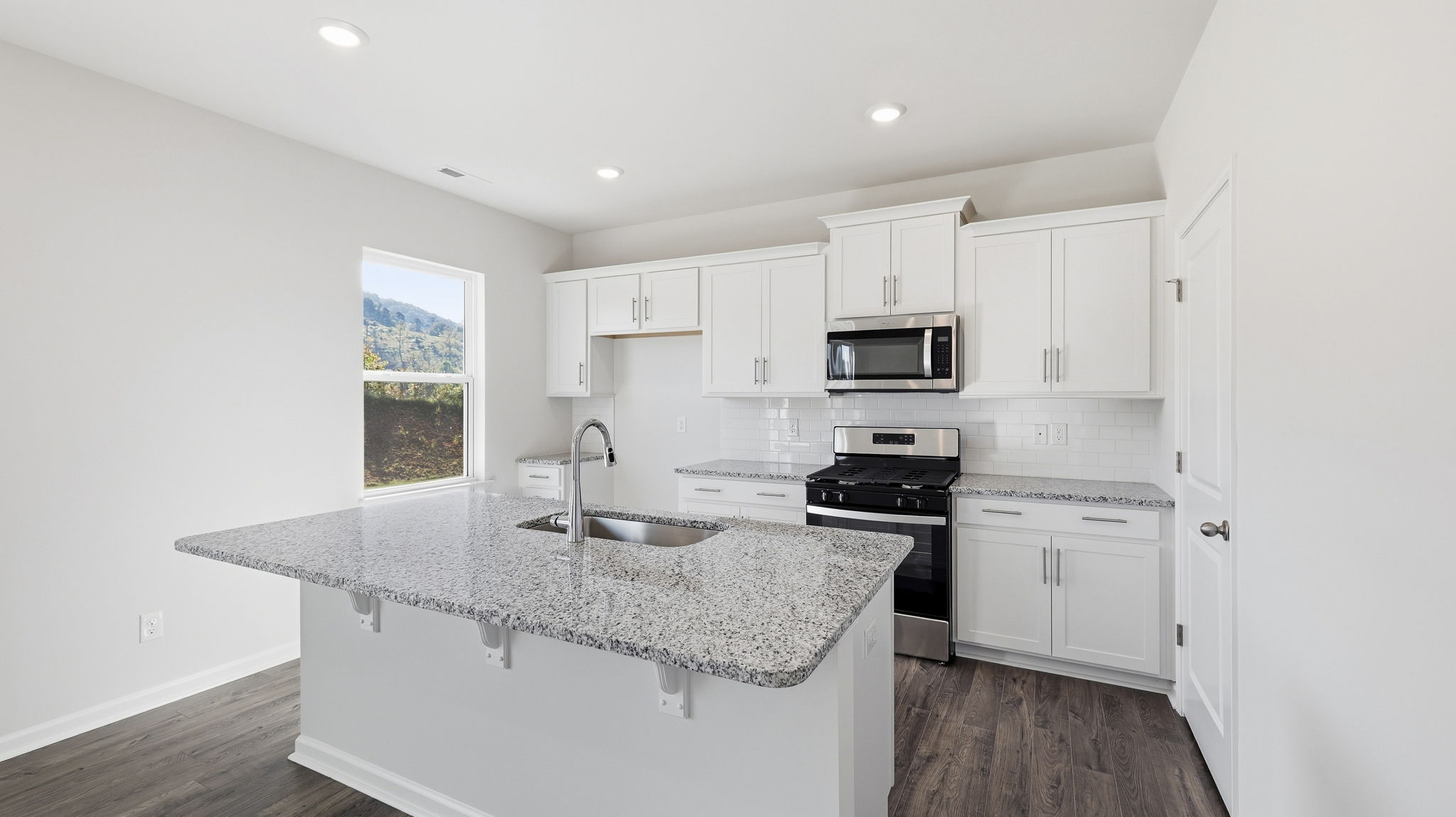 Open concept kitchen with large island and stainless steel appliances