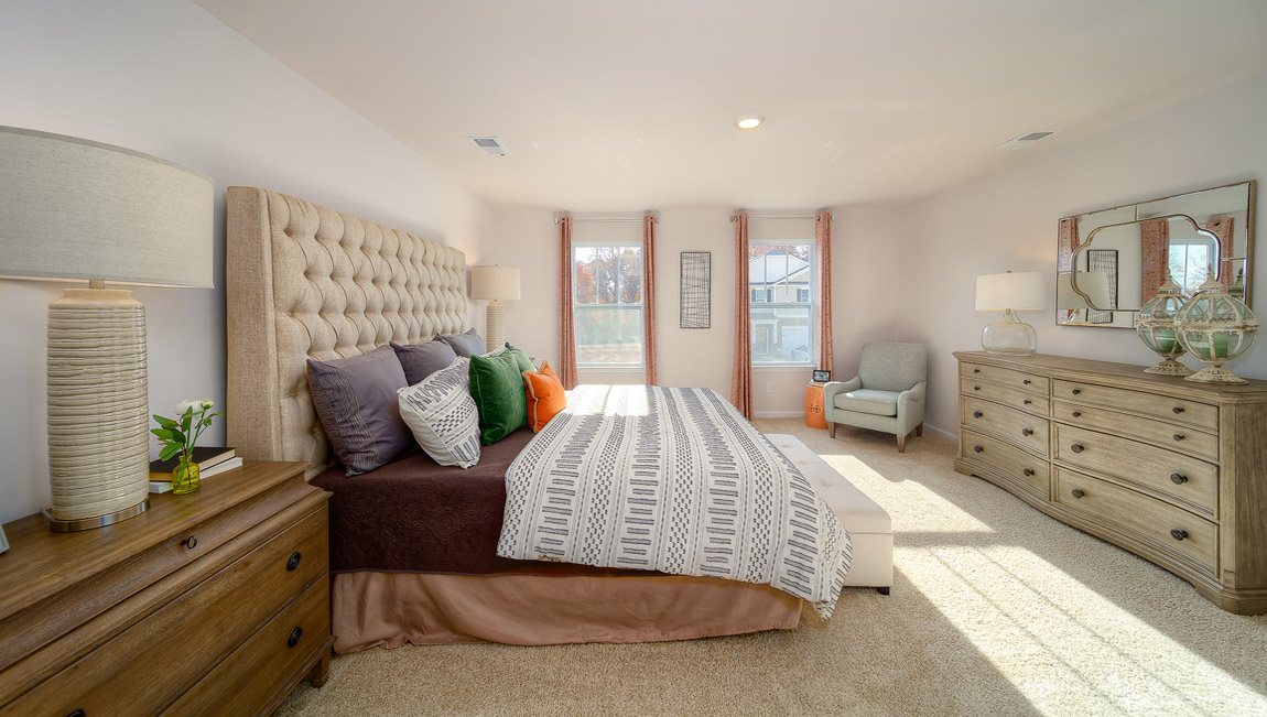 primary bedroom with carpet and two large windows