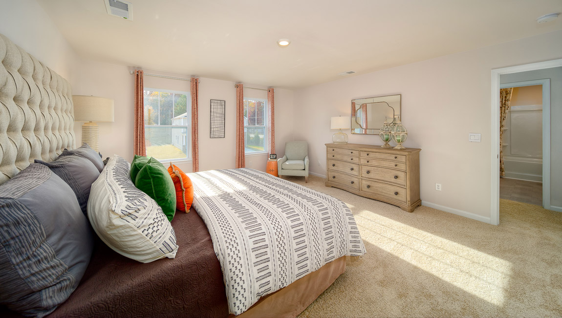 primary bedroom with carpet and two large windows