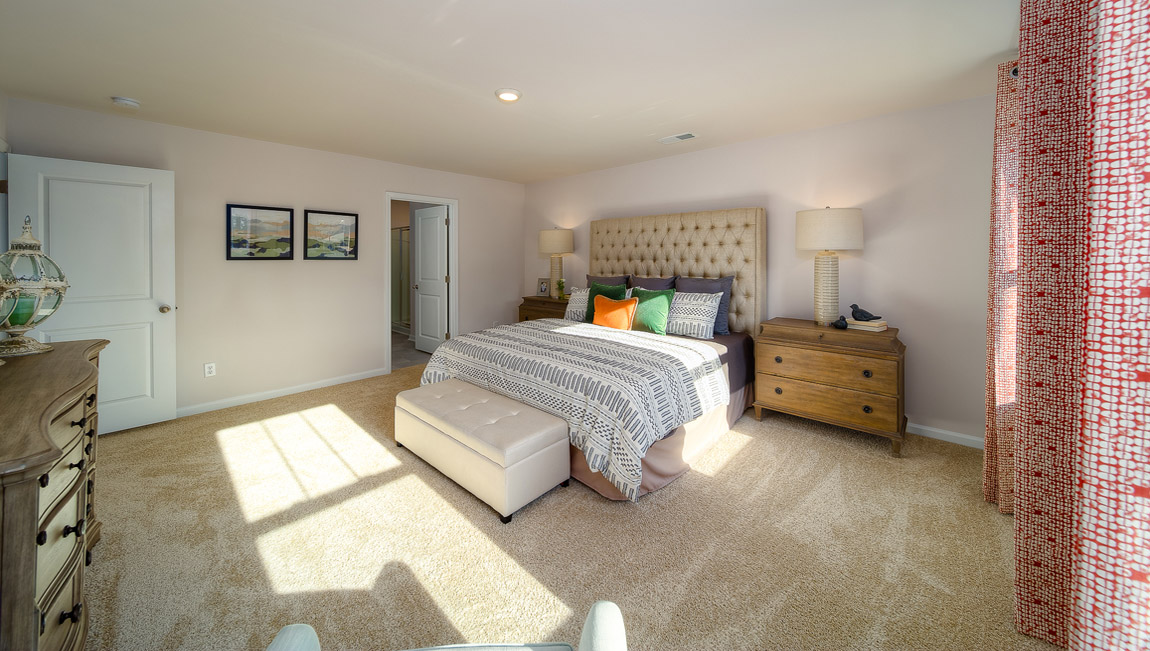 primary bedroom with carpet and two large windows