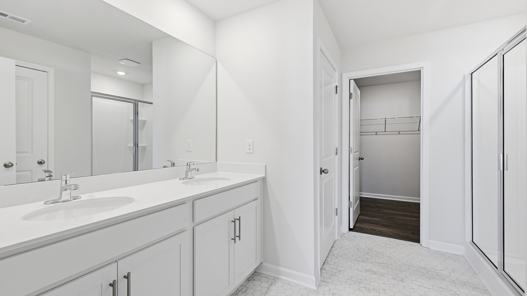 Primary bathroom with dual vanity and walk in shower