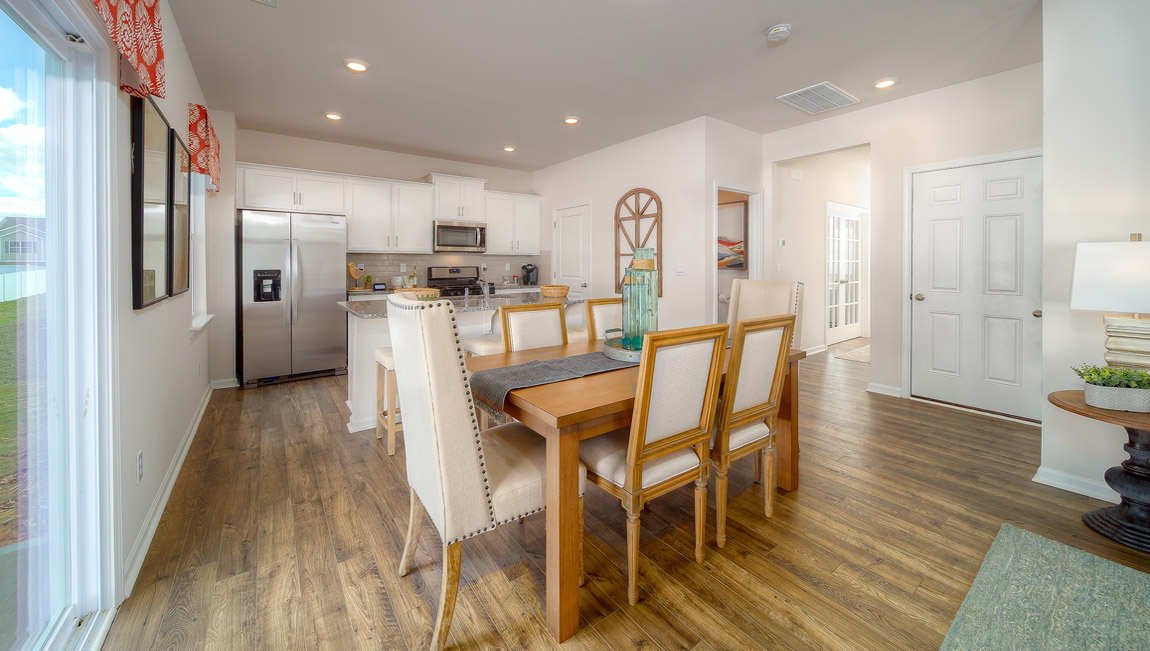 kitchen and island with white cabinets, wood floors and stainless steel appliances