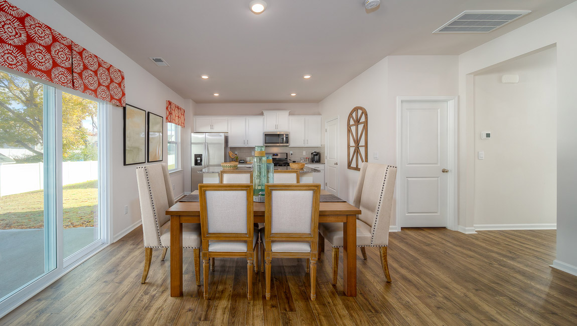 kitchen and island with white cabinets, wood floors and stainless steel appliances