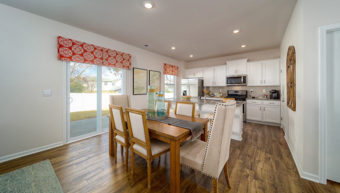 kitchen and island with white cabinets, wood floors and stainless steel appliances