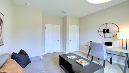 Carpeted bedroom used as an office space with small window