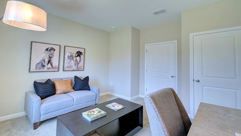 Carpeted bedroom used as an office space with small window
