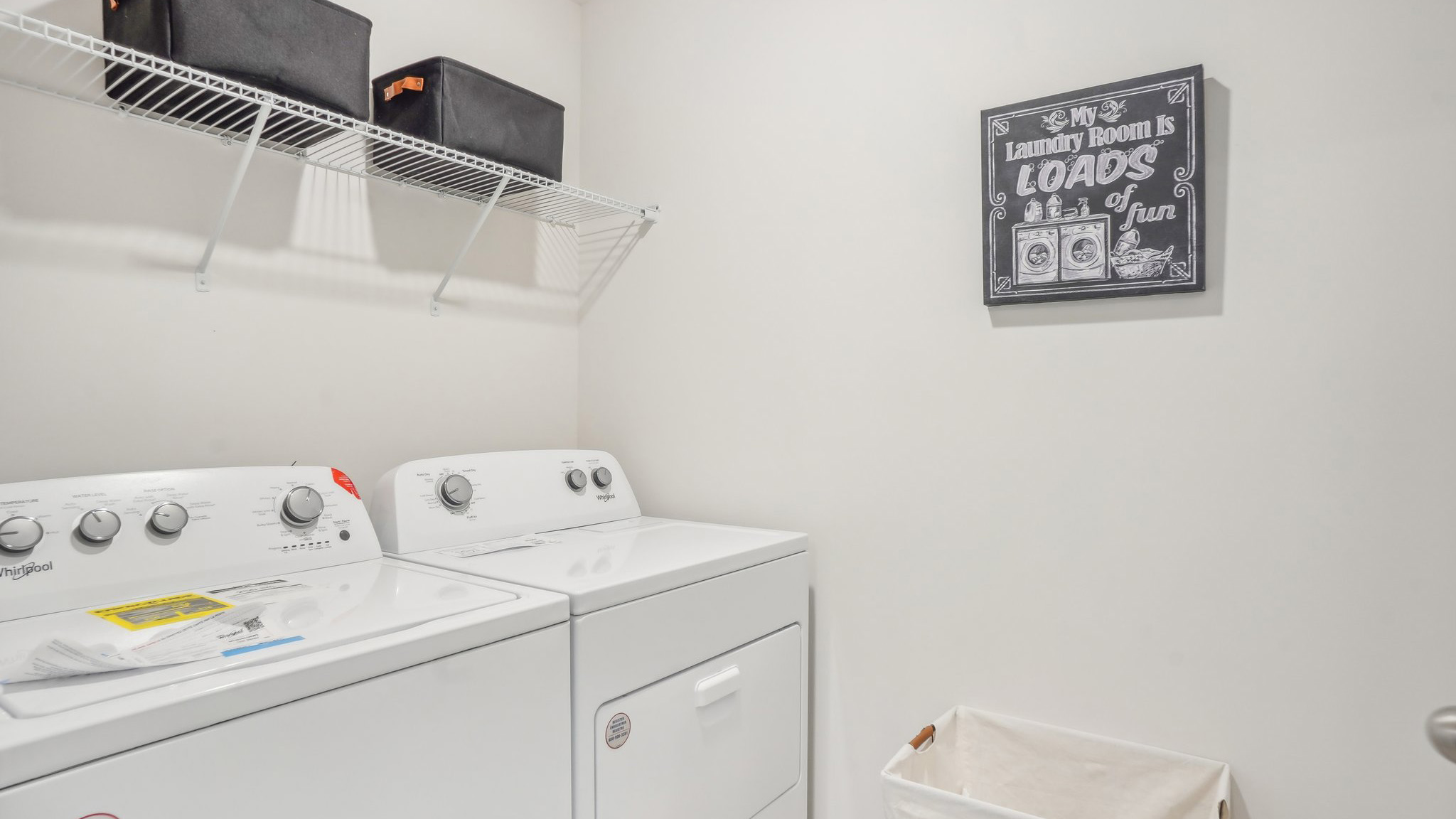 Model laundry room with rack above machines