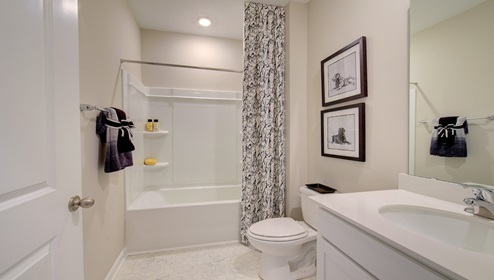 Bathroom with white cabinets and counters, and bathtub shower combination