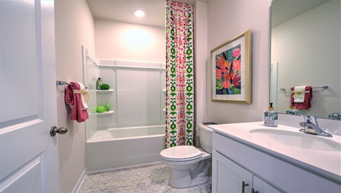 Bathroom with white cabinets, and counters, and bathtub