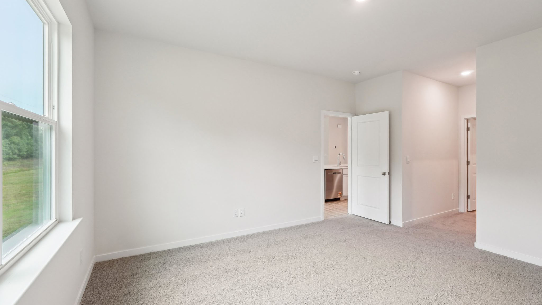Carpeted bedroom with large window